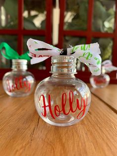 an empty glass bottle with the word holly painted on it sitting on a wooden table