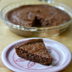 a piece of chocolate cake sitting on top of a plate next to a pie pan