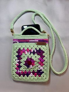 a crocheted cell phone case with a strap attached to the back of it