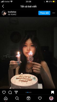 a woman holding a cake with candles in front of her face and the number eight on it