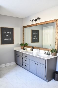 a bathroom with two sinks and a large mirror on the wall above it is also a chalkboard sign that says start and do work