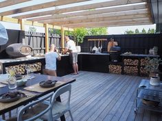 two people are cooking on the outdoor kitchen