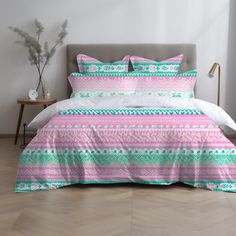 a bed with pink and green bedspread in a bedroom next to a nightstand