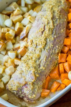 meat and vegetables in a casserole dish on a wooden table