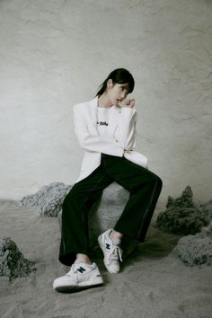 a woman sitting on top of a cement block