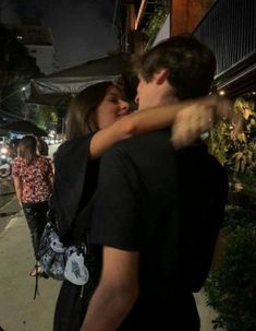 a man hugging a woman on the street at night