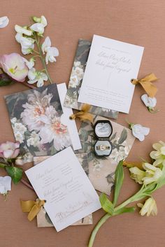 the wedding stationery is laid out with flowers