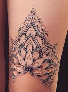 a woman's thigh with a tattoo design on the leg and an image of a flower