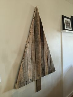 a wooden christmas tree hanging on the wall