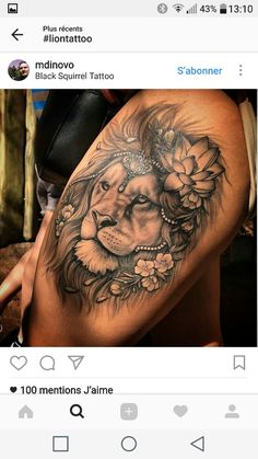 a woman's thigh with a lion tattoo on it and flowers in the middle