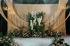 a wedding stage decorated with flowers and greenery