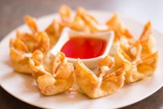 a white plate topped with waffles covered in ketchup and dipping sauce