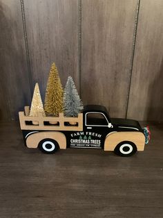 a toy truck with christmas trees in the bed and on the back is a sign that says farm fresh