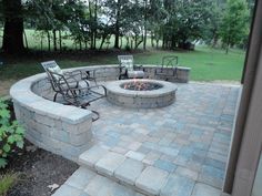 an outdoor fire pit with chairs around it