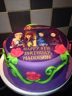 a birthday cake with pictures of the characters on it and roses in the middle, sitting on top of a table