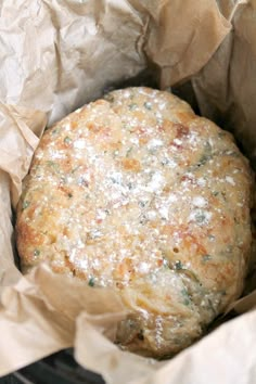 a close up of a food item in a paper bag on a metal rack with wax paper