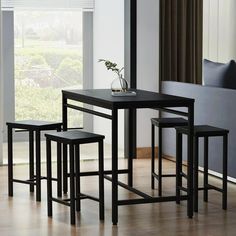 a black table and four stools in a room