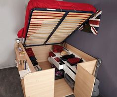 the bed is made up and has two drawers under it, as well as an overhead storage unit