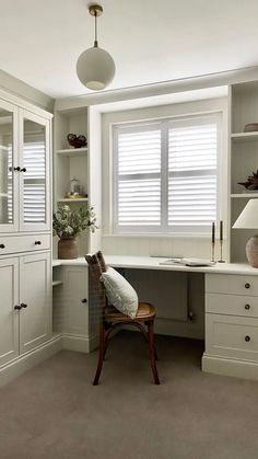 a white desk and chair in a room next to a window with shutters on the windowsill