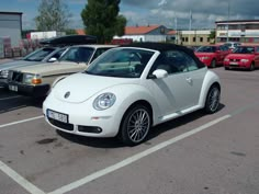 a white car parked in a parking lot next to other cars