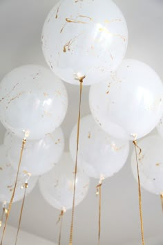 white balloons with gold splatters hanging from the ceiling