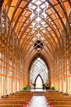 the inside of a church with rows of wooden pews and red seats on each side