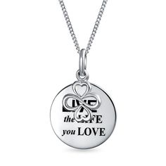 A beautiful expression of AYLLU's ideals of love, luck and unity, this stunning sterling silver pendant necklace features a dangle AYLLU charm attached to a round disc featuring the inspirational phrase "Live the Life You Love."  Serving as a poignant reminder we are forever entwined in a global community. Packaged in handcrafted gift boxes with a pamphlet telling the story of Ayllu's community. Symbolic Sterling Silver Charm Necklace For Gift, Sterling Silver Symbolic Charm Necklaces For Gifts, Symbolic Heart Charm Necklace For Gift, Inspirational Pendant Charm Necklace As Gift, Sterling Silver Charm Necklaces As Gift, Sterling Silver Charm Necklace As Gift, Inspirational Pendant Charm Necklace For Gift, Inspirational Charm Necklaces As Gift, Inspirational Round Pendant Charm Necklace As Gift