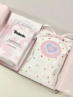 an open box with a pink bow on the top and polka dot designs on the bottom