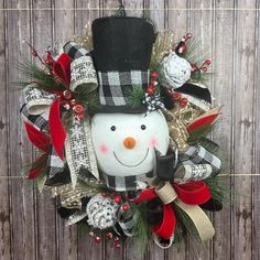 a christmas wreath with a snowman wearing a top hat