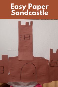 a child's hand holding up a piece of paper with the words easy paper sandcastle