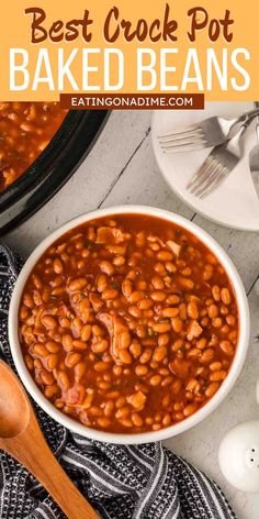 the best crock pot baked beans in a white bowl with spoons and plates