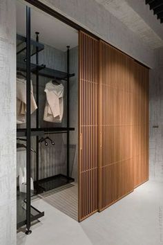 an open closet with clothes hanging on shelves