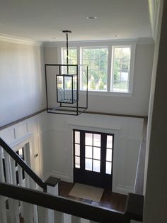 an empty room with white walls and wood floors is seen from the second floor looking down