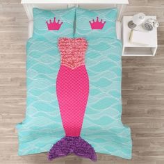 a bed with a pink and blue mermaid design on it