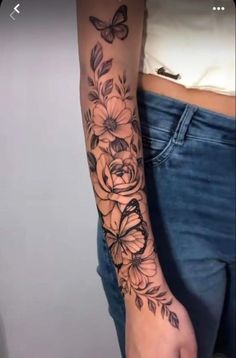 a woman's arm with flowers and butterflies on it