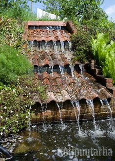 a water fountain in the middle of a garden