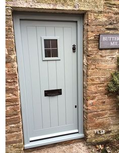 a stone building with a blue door and sign on the outside wall that says butternut mill