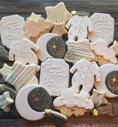 decorated cookies with stars, moon and clouds are on a table next to a wooden board