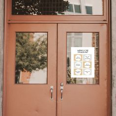 two brown doors with signs on them in front of a building