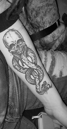 a person with a tattoo on their arm that has an octopus and snake on it