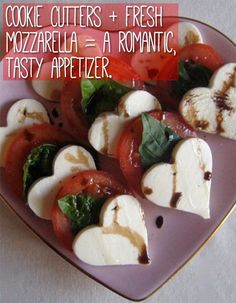 a plate filled with sliced tomatoes and mozzarella on top of a white table