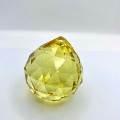 a yellow diamond sitting on top of a white table