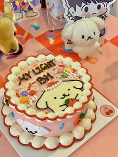 there is a birthday cake on the table with two stuffed animals next to it,