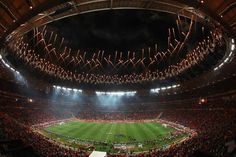 fireworks are lit up in the air above a soccer stadium as spectators watch from the stands