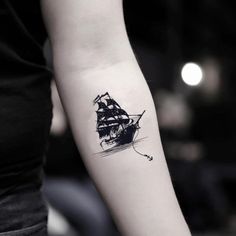 a woman's arm with a ship tattoo on it