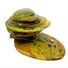 three glass bowls stacked on top of each other in different colors and shapes, one is yellow and the other is green