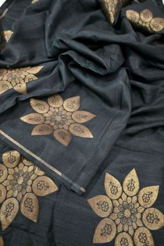 Come up with a different style with our new muga banarasi saree with a fantastic floral motif design on the body and golden zari work all over the saree, making this saree a distinguished piece in a lovely shade of coal black color. Color: A shade of coal black color Technique: Comes with allover zari work with floral pattern work on the body Fabric: Muga Silk Quality: Indyvogue's Assurance of Pure Silk Mark Certified Saree Unstitched Slub Silk Blouse Piece With Zari Work, Elegant Tussar Silk Embroidered Fabric For Festivals, Elegant Tussar Silk Fabric For Festivals, Elegant Tussar Silk Unstitched Suit For Navratri, Navratri Slub Silk Blouse Piece With Motifs, Designer Tussar Silk Saree With Motifs, Designer Wear Tussar Silk Saree With Motifs, Navratri Slub Silk Blouse Piece With Traditional Patterns, Traditional Saree Blouse Piece In Slub Silk