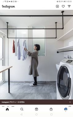 a woman standing in front of a dryer next to a washer and dryer