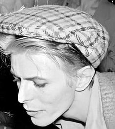 a black and white photo of a woman with a hat on top of her head