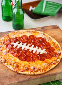 a pepperoni and cheese football pizza on a cutting board